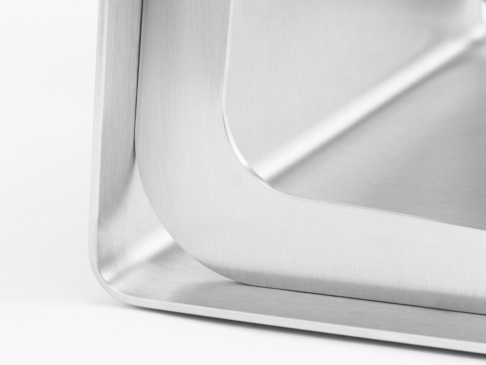 Particolare dello spigolo in acciaio inox dello sgabello di design Dado